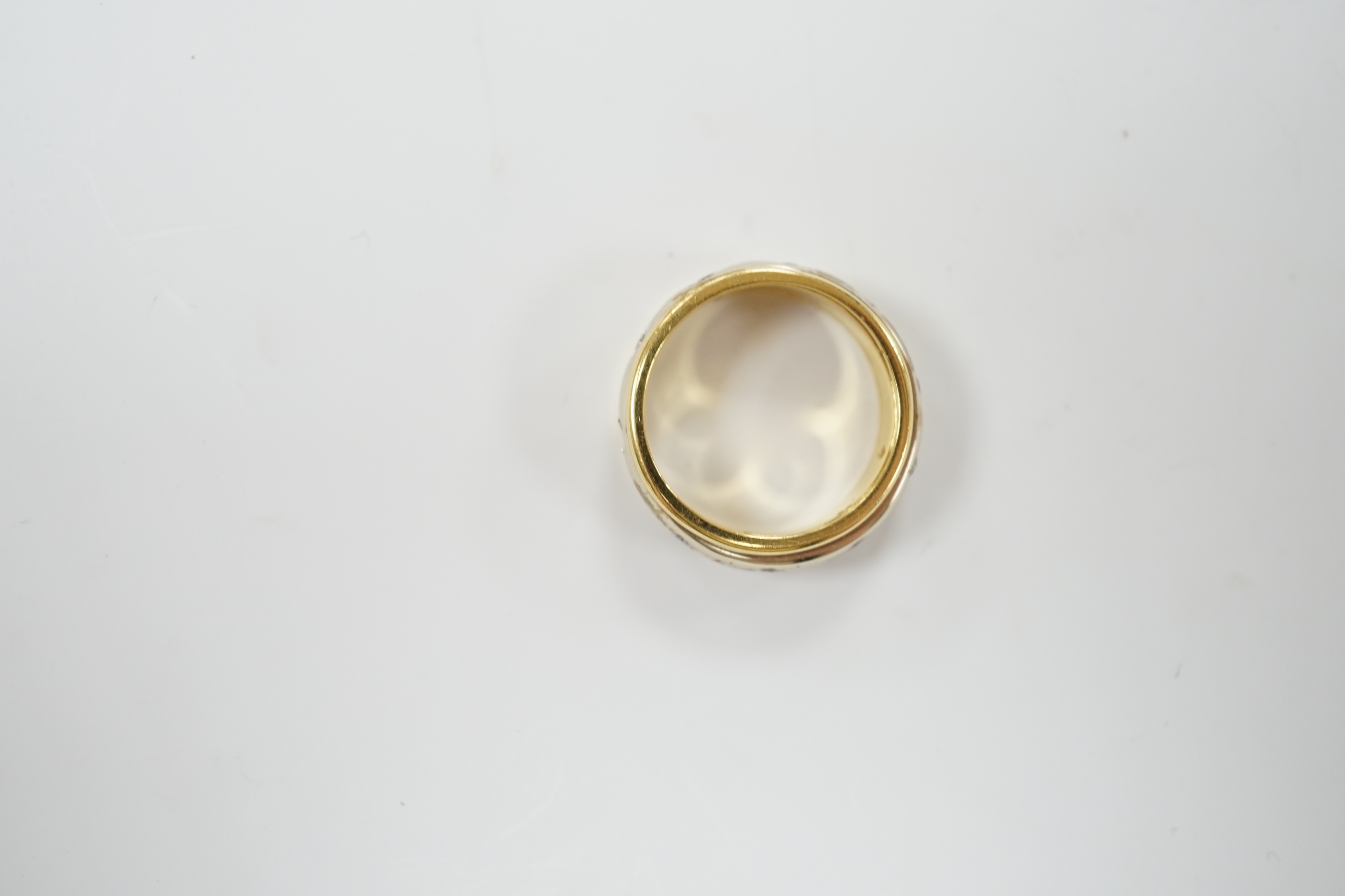 A modern 750 yellow metal ring, with central diamond set rotating white metal band (stone missing), size P/Q, gross weight 7.9 grams.